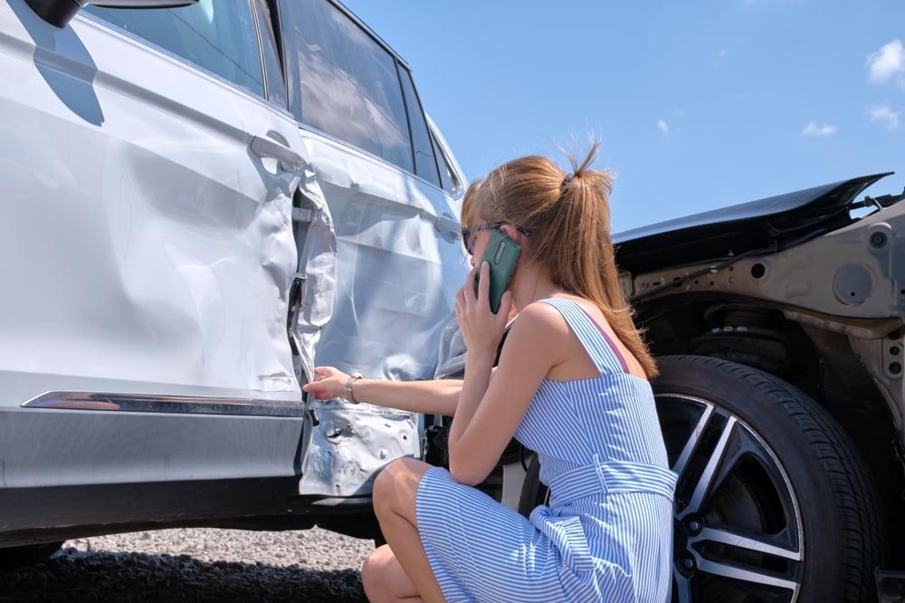 woman checking damages in a car after a crash