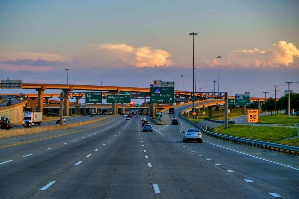 Houston freeway interchanges and overpasses with traffic at sunset