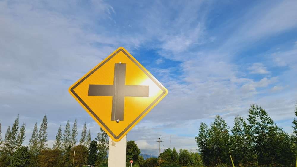 Yellow intersection warning sign alerting drivers to an upcoming road intersection.