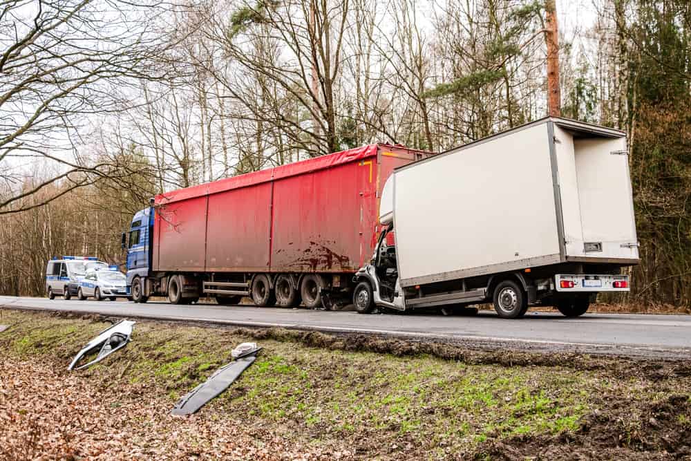 Box truck lodged beneath the rear of a semi-truck trailer following a rear-end truck accident.