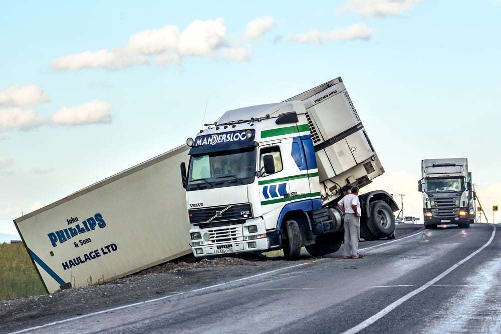 Jackknifed semi-truck blocking part of a highway after a commercial truck accident.