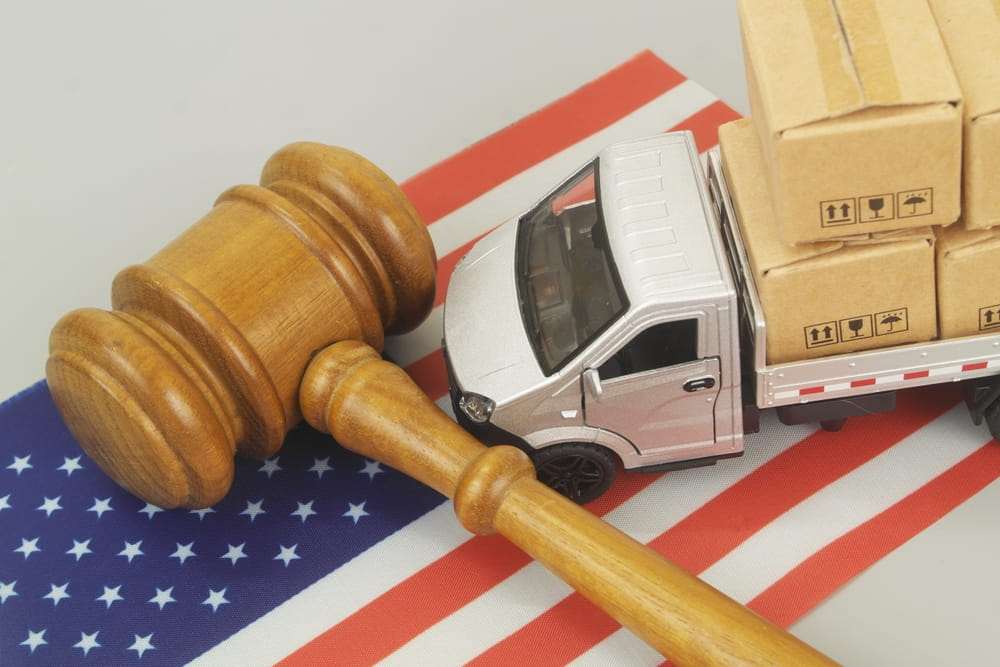 Mazo de juez junto a una camioneta de reparto de juguete con cajas