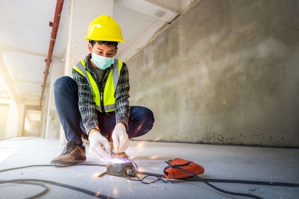 Construction worker wearing protective gear while performing welding on a job site