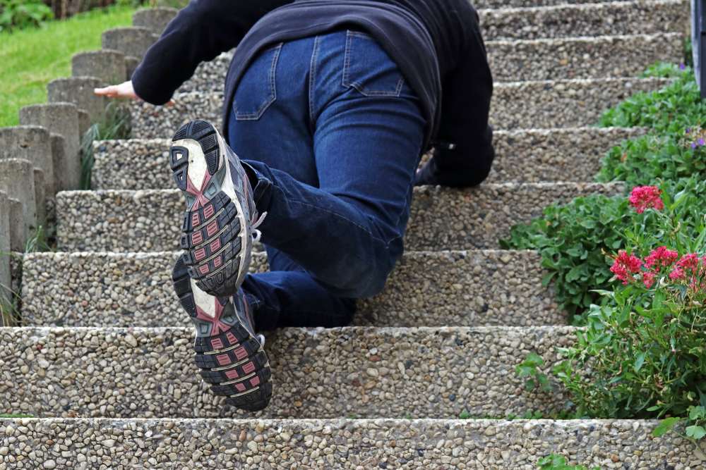 Woman falling while walking up a flight of stairs